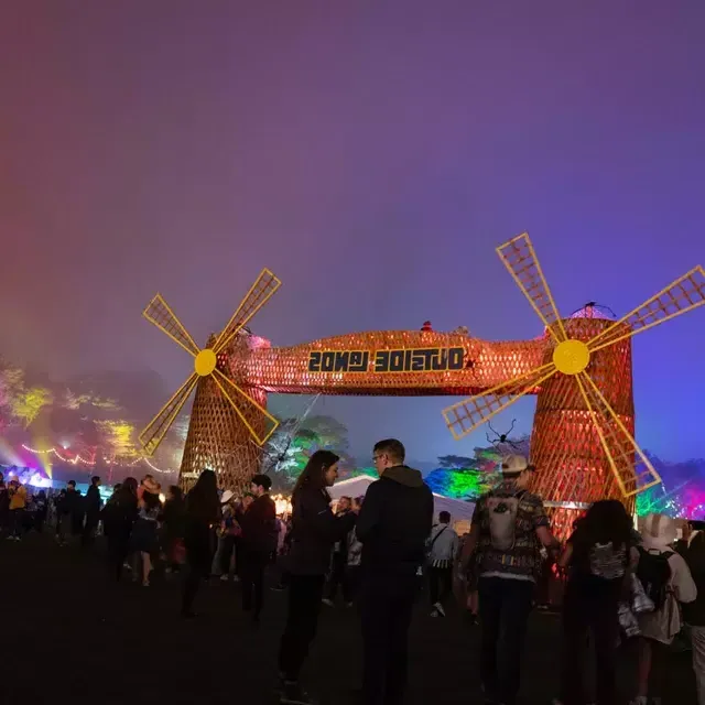 Une foule de festivaliers est photographiée la nuit au milieu des néons au festival de musique Outside Lands à San Francisco.