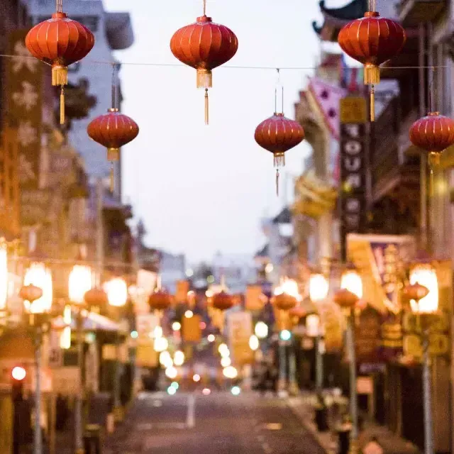 Primo piano di una fila di lanterne rosse appese sopra una strada di Chinatown . San Francisco, California.